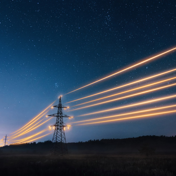 Electricity pylon at night with glowing wires