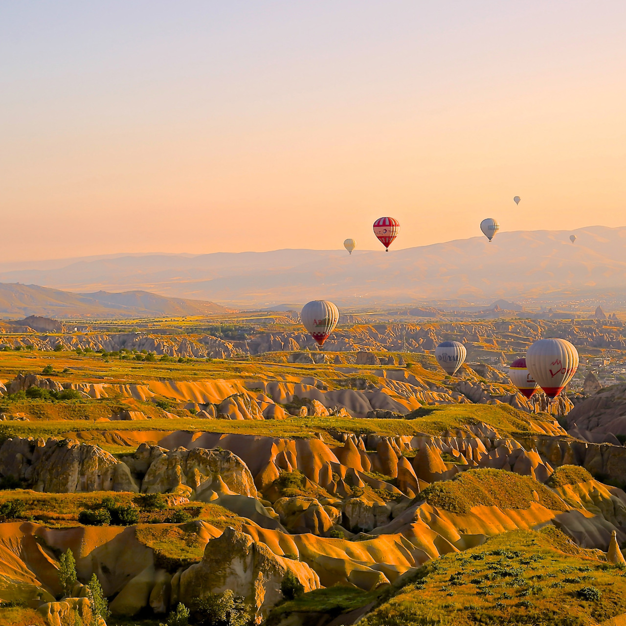 Hot air balloons over rocky valleys