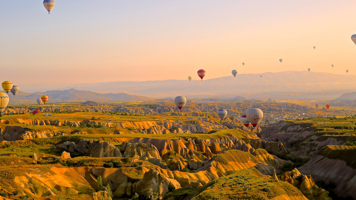 Hot air balloons over rocky valleys