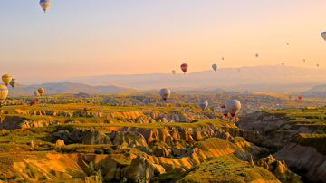Hot air balloons over rocky valleys